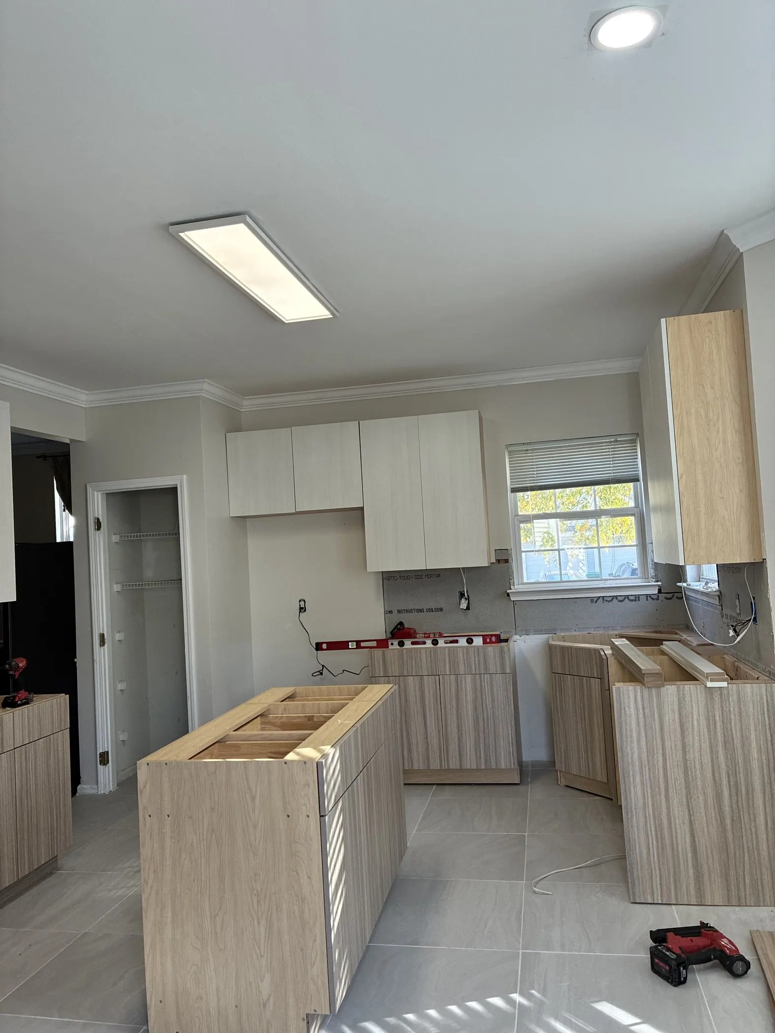 Kitchen with new cabinets installed and open lower cabinet bases.