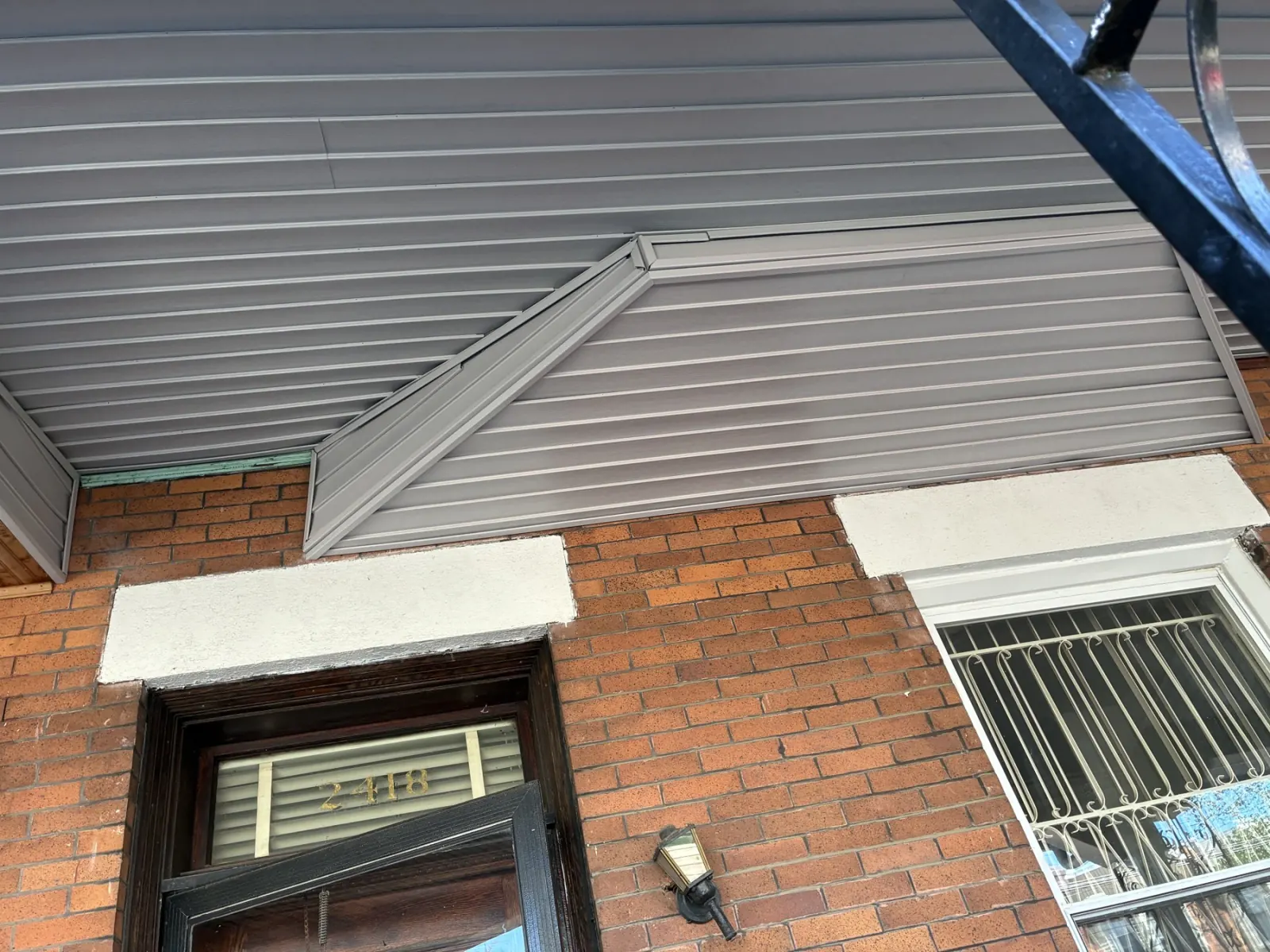 Gray covering installed above the porch doorway and window.