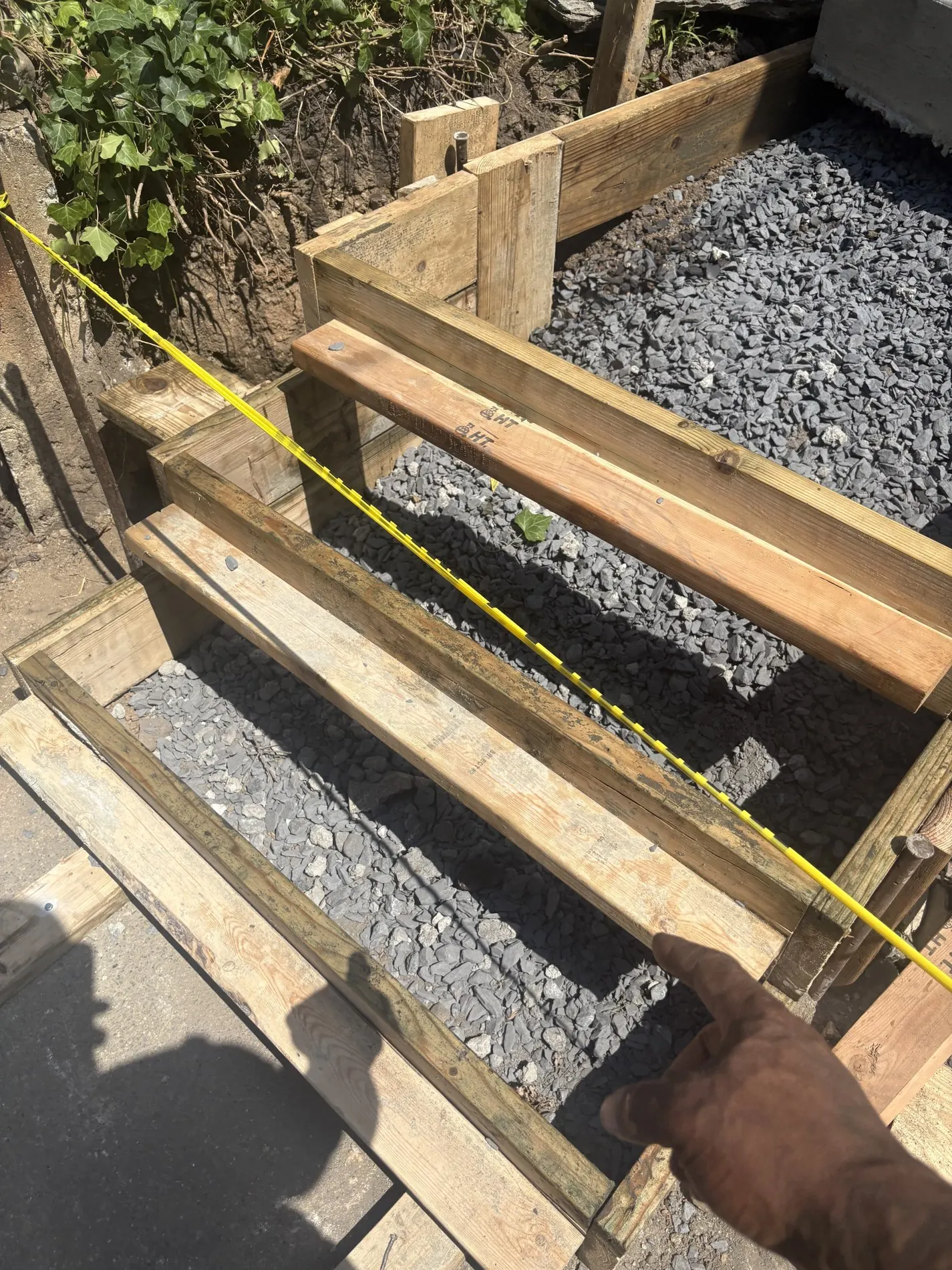 Timber stair forms and aggregate below an existing upper staircase.