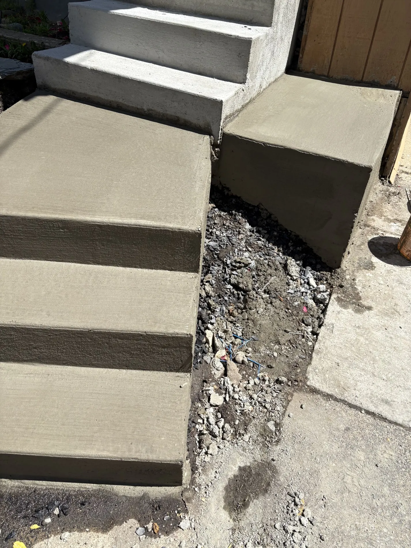 Freshly poured concrete lower steps and square landing.