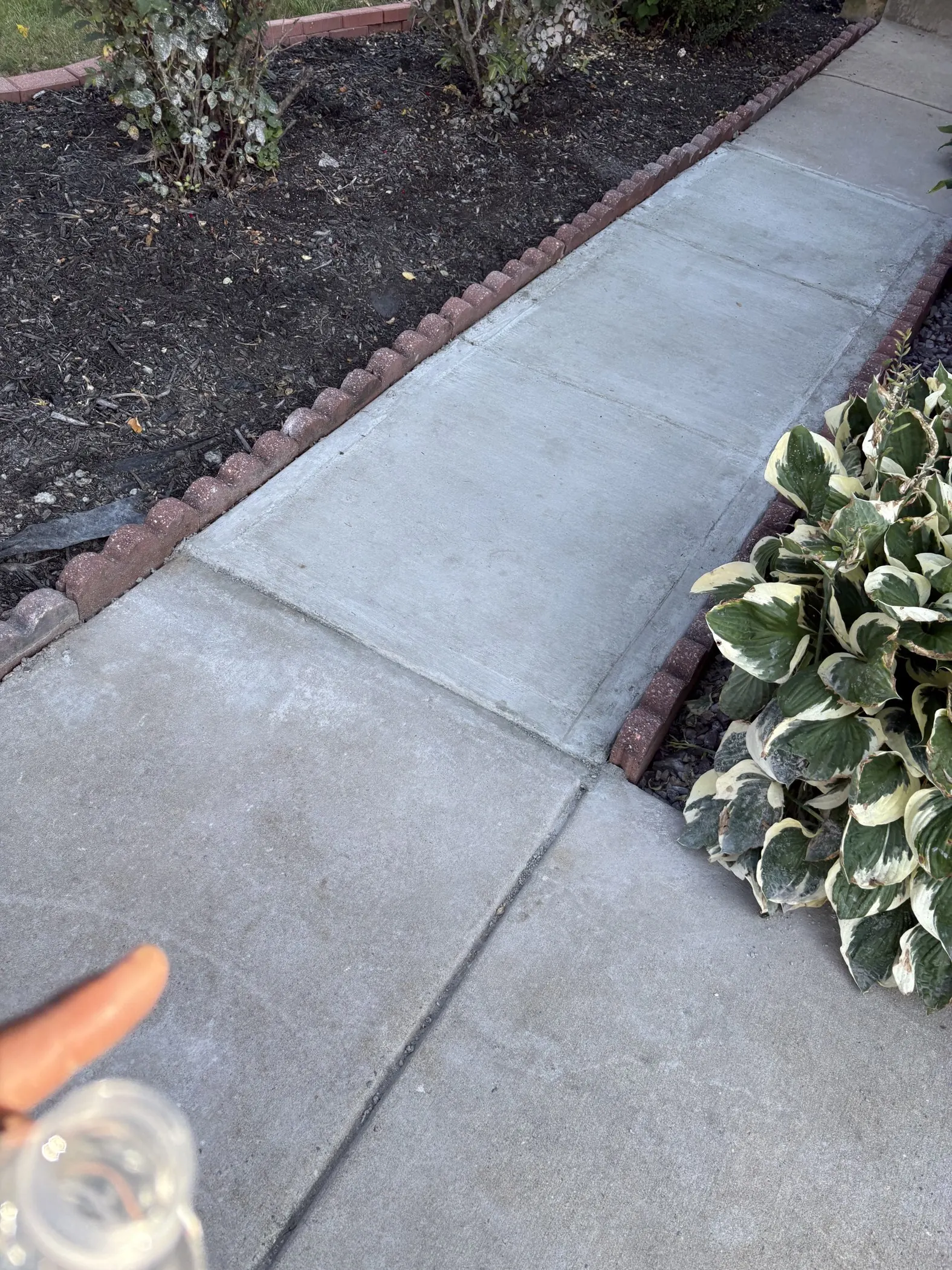 Replacement concrete walkway section between existing slabs.